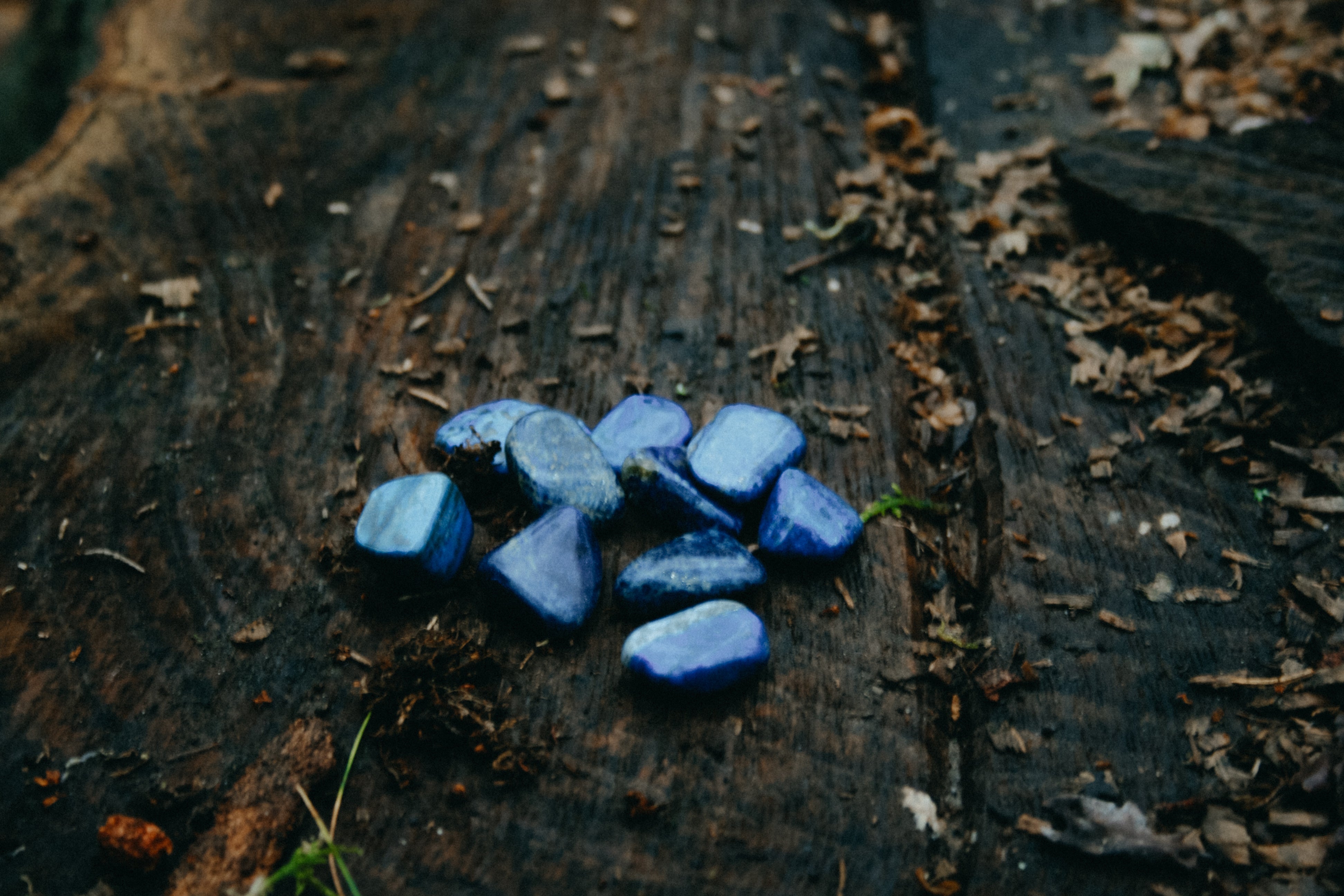 Edelsteen Lapis Lazuli trommelstenen op houten ondergrond - spirituele werking, rust en inzicht.