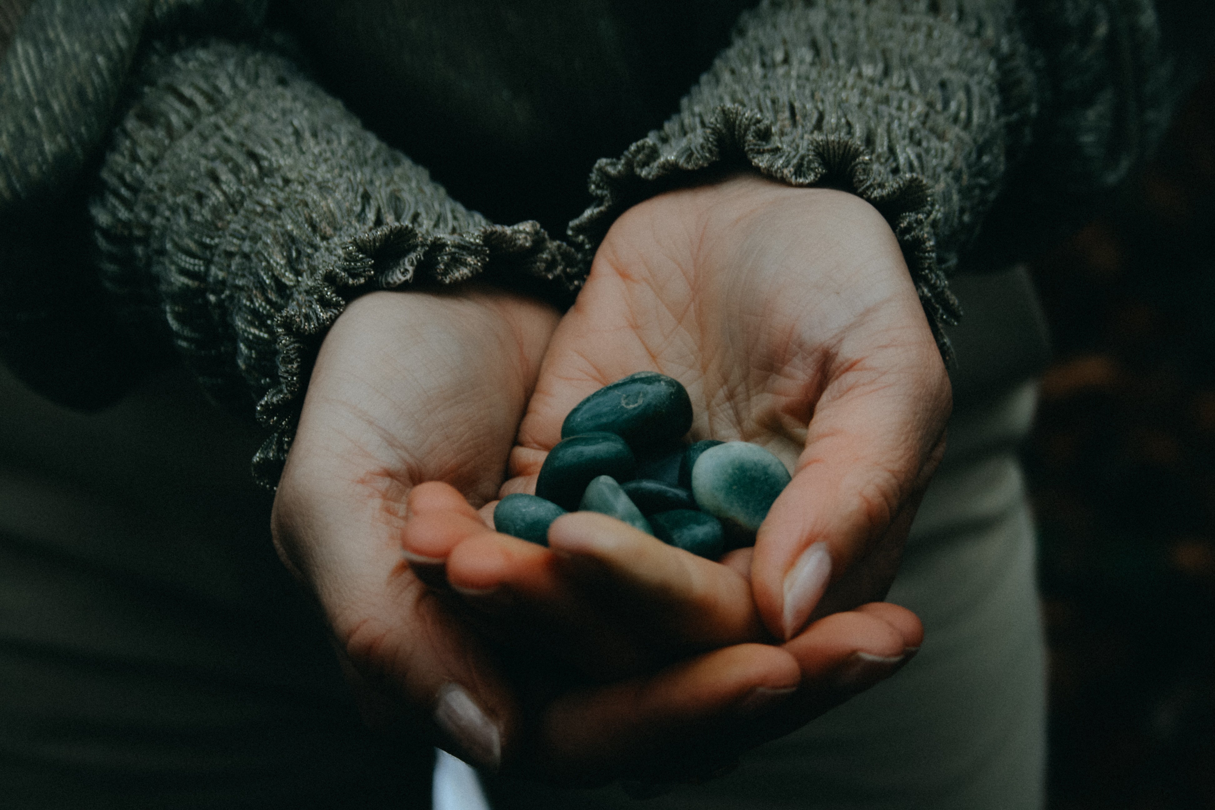Handen met groene aventurijn edelstenen- helende kristallen voor balans, bescherming en zelfliefde. Spirituele edelstenen kopen bij Alchemy of Light in Nederland.