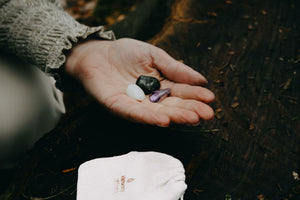 Hand met edelstenen labradoriet, amethist en maansteen – spirituele stenen voor spirituele ontwikkeling en intuïtie.